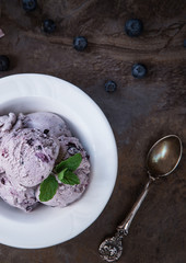 Blueberry homemade ice cream with mint leaves on stone slate background