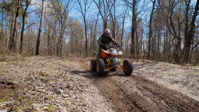 Extreme vacation in the woods on the ATV. Men engage in motor sport, quad bike is an ideal means for riding on country roads. All wheel drive helps to overcome obstacles, and to conquer the terrain