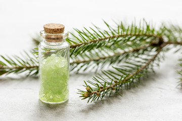 spa with organic spruce sea salt in glass bottles on white table background