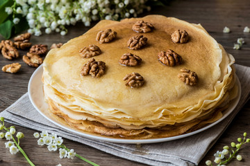 Delicious pancakes on wooden table with walnuts.