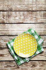 Empty plate with napkin on brown wooden table