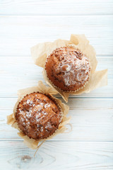 Tasty muffins on white wooden table