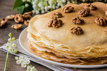 Delicious pancakes on wooden table with walnuts.