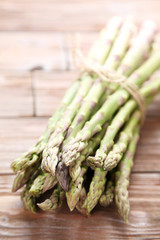 Bunch of green asparagus on brown wooden table