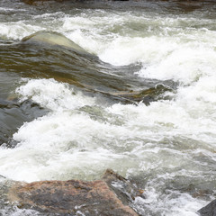 Stromschnelle in einem Fluss mit weißer Gischt