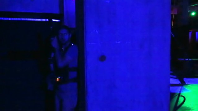Male player hiding from rival with lasertag gun, enjoying realistic combat game
