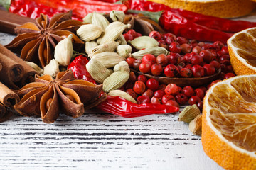 Christmas spices, fruits, nuts and berries on the wooden background