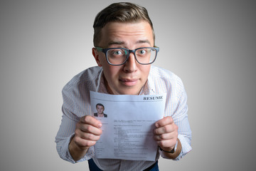 A funny guy keeps his resume in his hands and wants to get a job