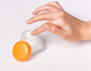 Female hand with cosmetic cream isolated on white background.