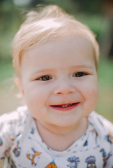 Serious 1-year infant boy during his first haircutting
