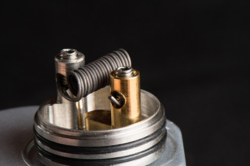Vaping device with a spring on a black background for evaporation
