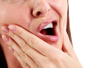 Closeup of woman in strong toothache pain with hands over face. Dental health and care concept....