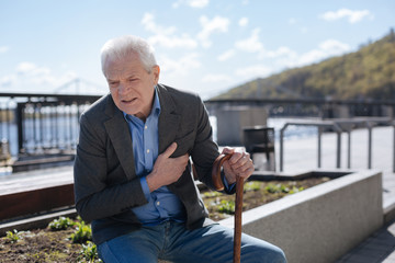 Confused man feeling heart attack on the quay