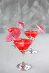 Raspberry cocktail with ice and paper umbrellas