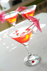 Raspberry cocktail with ice and paper umbrellas