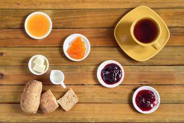 Crispy rolls with butter, apple jelly and hot tea for breakfast