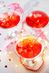 Raspberry cocktail with ice and paper umbrellas