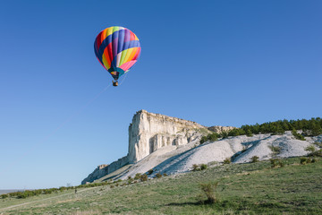 Fototapeta na wymiar Hot Air Balloon Floating near White Rock