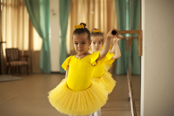 Cute little ballerina in golden ballet dress