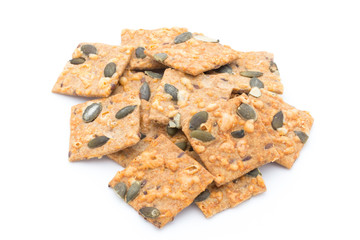 Autumn themed baked crisps with cranberries, nuts and seeds stacked on a white background.
