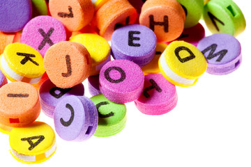 Chaotically folded multicolor circles with letters written on them. Diagonally laid on a white background