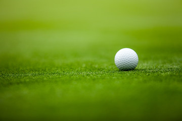 Golf ball on tee in the grass.