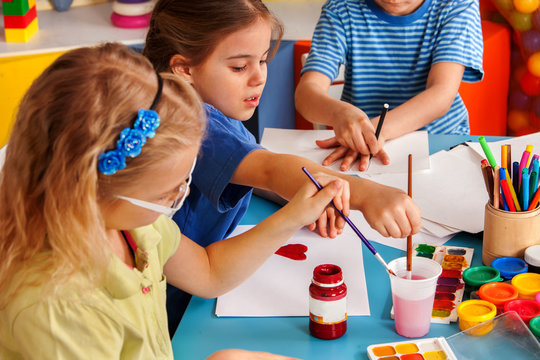 Small students girls painting in art school class. Children boy and girl drawing by paints on table. Children have fun at the children's club. Craft drawing education develops creative abilities of