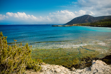 View to the Cyprus island sea coast with blue water and mountain. Akamas cape landscape. Natural seasonal summer vacation background.