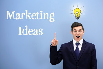 Attractive young man in a suit against light blue wall