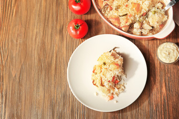 Tasty rice with chicken and vegetables on wooden table
