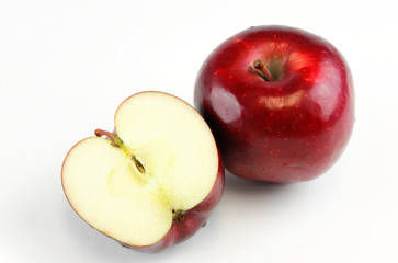 red apple with one cut in half on white background