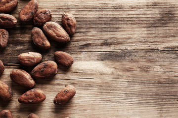 Aromatic cocoa beans on wooden background