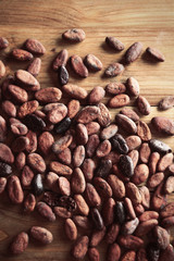 Aromatic cocoa beans on wooden background