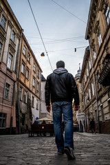 Fototapeta na wymiar man walking by old europian city