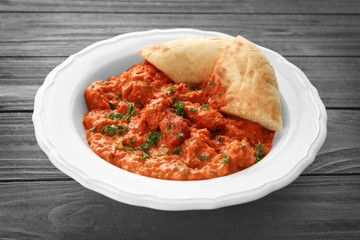 Plate with delicious Murgh Makhani on grey background