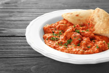 Plate with delicious Murgh Makhani on grey background