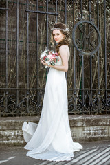 Fototapeta premium Brunette bride in fashion white wedding dress with makeup