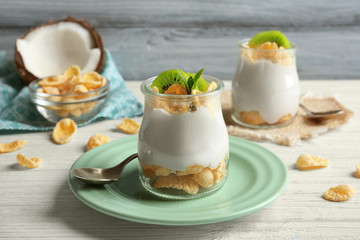 Delicious coconut cream in jar on wooden background