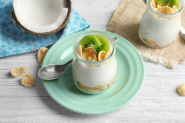 Delicious coconut cream in jar on wooden background
