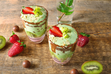 Delicious parfait with fruits on wooden background