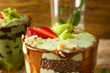 Delicious parfait with fruits in glass, closeup