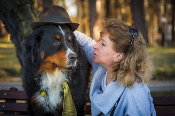 woman with bernese mountain dog on nature