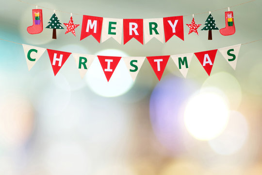 Merry Christmas bunting flag over blur festive bokeh light background, greeting card banner