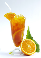 Glass of fresh orange tea with aloe vera leaf on white background