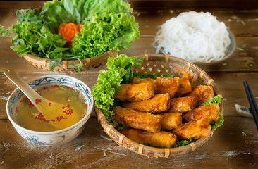 Fototapeta na wymiar Vietnamese crispy spring rolls with vermicelli, lettuce and fish sauce