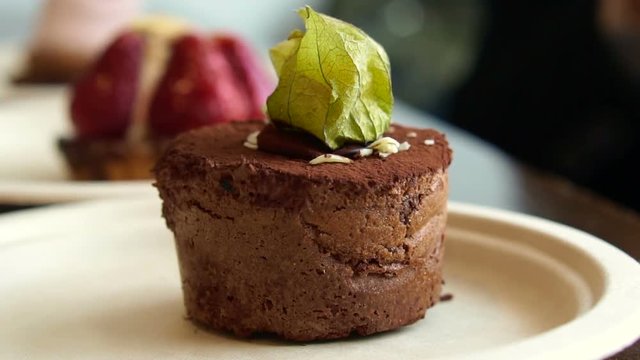 Close up texture lava dark chocolate cake with cape gooseberry topping serve in bakery