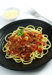 Spaghetti ramen noodle pasta  with tomatoes sauce on black dish