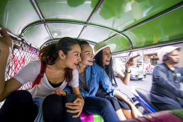 Naklejka premium Three asian girls are exploring Chinatown, Thailand by Tuk tuk