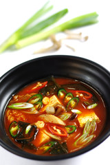 Hot chili tofu soup with onion in black bowl