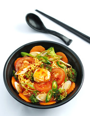 Hot chili ramen noodle with tofu and tomatoes in black stew
